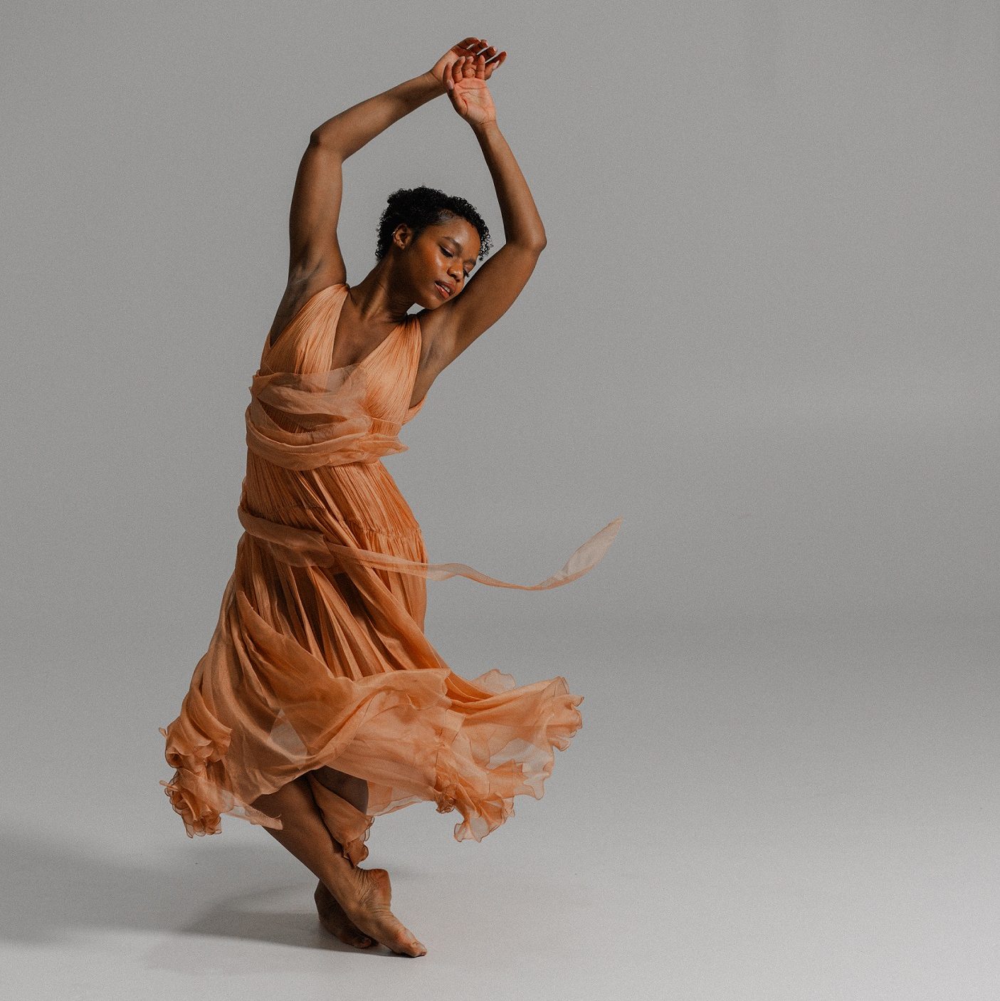 a woman dances against a white background