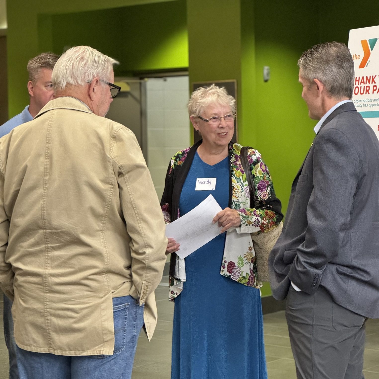 a woman and two men standing together talking