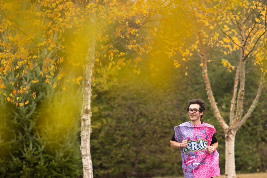 man in a Nerds costume runs through yellow smoke