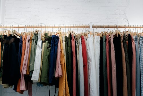a rack of pants and shirts in a range of colors and sizes