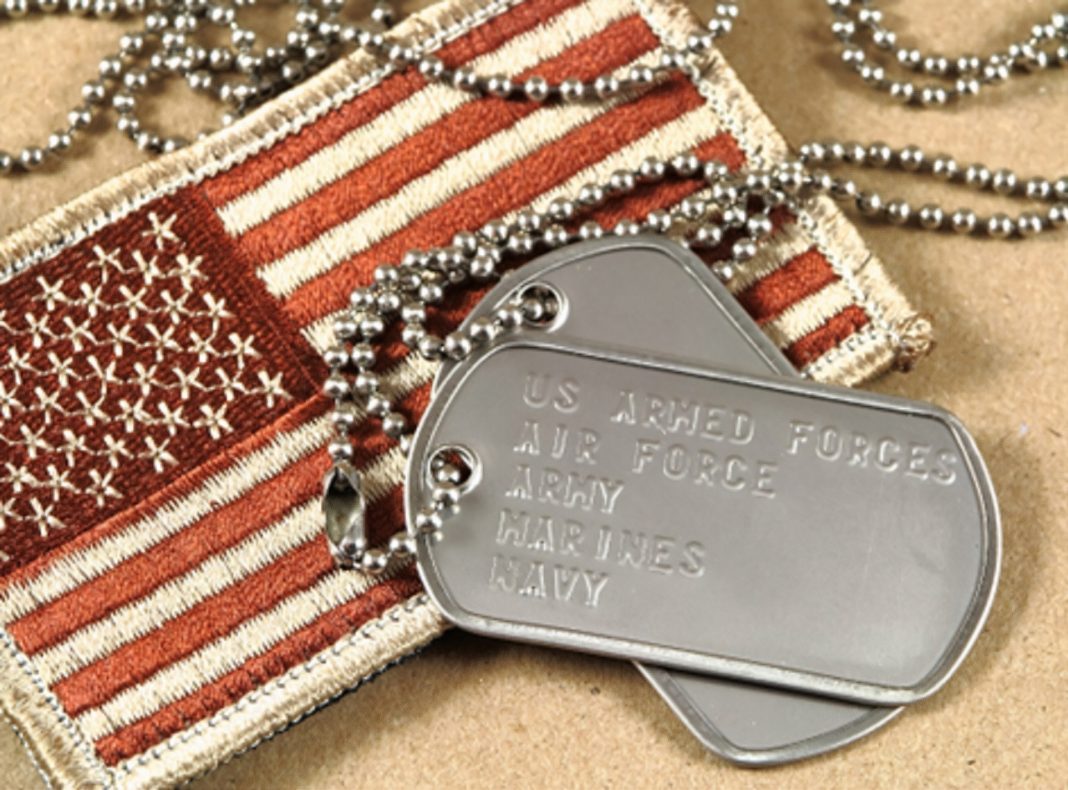 an American flag patch with a military dog tag on top of it.