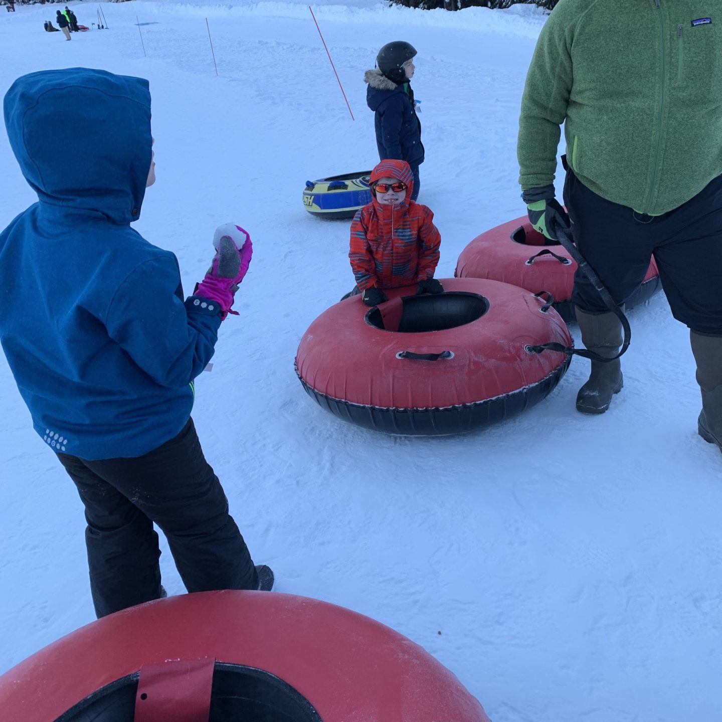 kids intertubing on a snowy slope