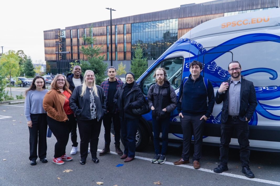 group of SPSCC students standing next to a blue and grey van with the letters 'SPSCC.edu' on it.