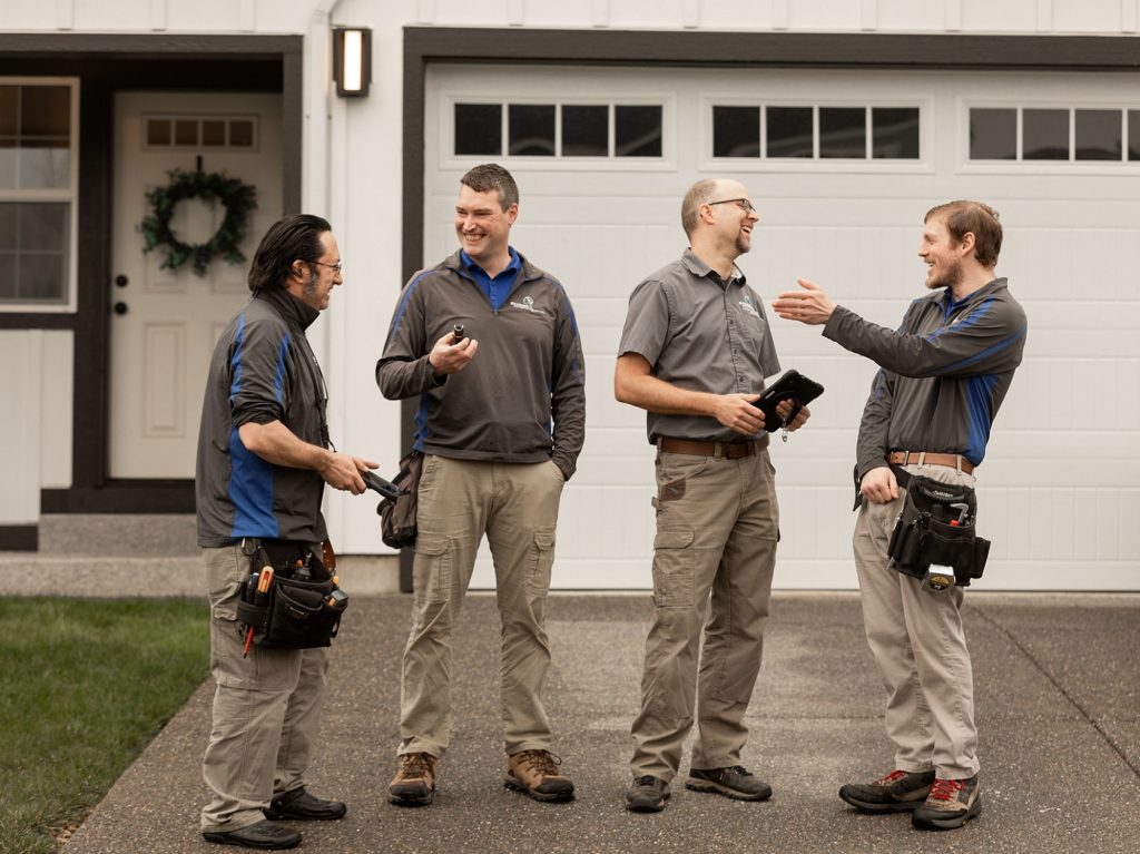 four Boggs technitions talking outside of a house