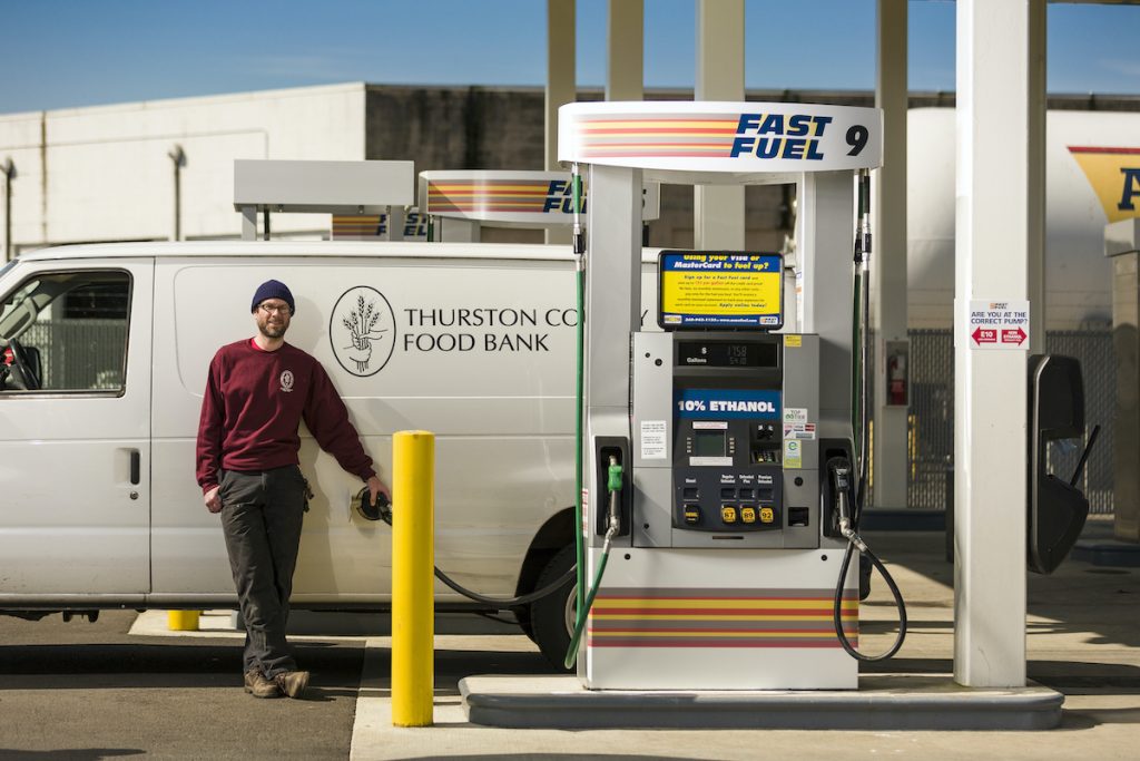 person fueling his white van at a Fast Fuel pump