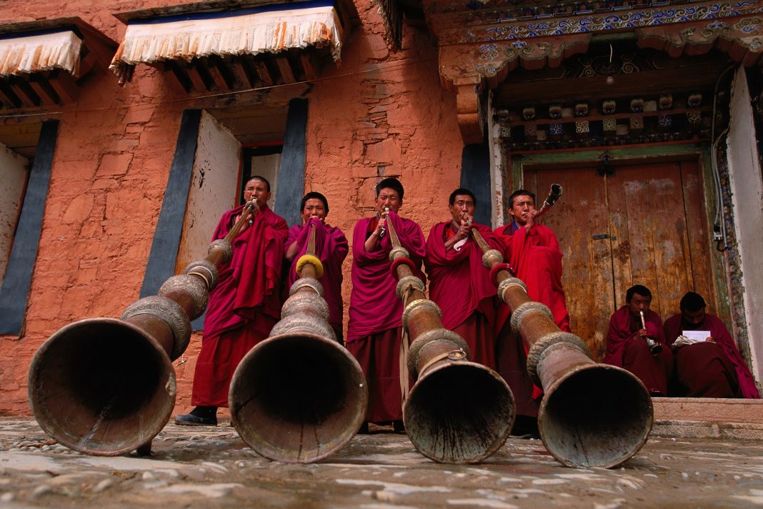Labrang Monastery, novice monks (trapa), practice blowing the dungchen, traditional 13-foot horns, that will be used in Buddhist ceremonies and call to prayer. The sound can be compared to the singing of elephants. (Labrang Monastery, novice monks