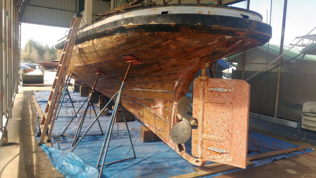 the tugboat Parthia in a boathouse being restored