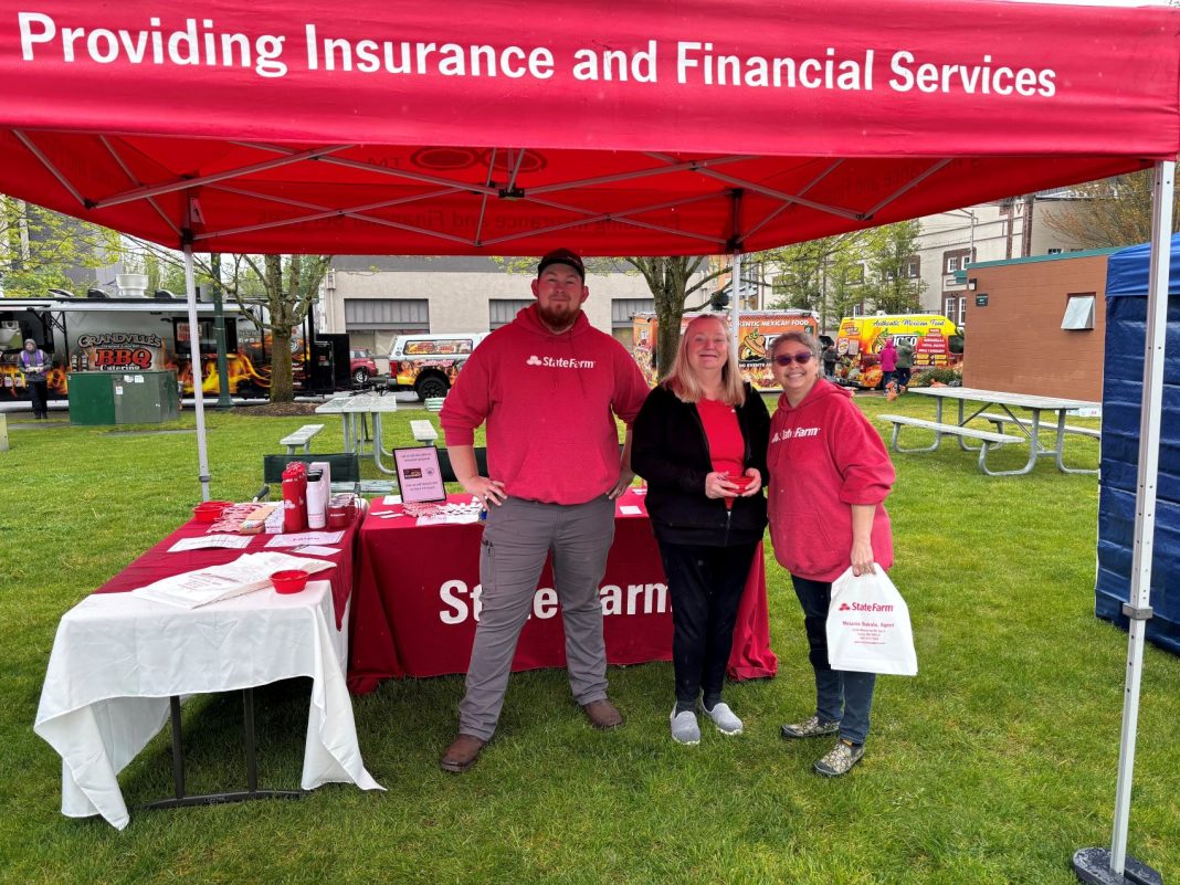 three people in red state farm shirts pose for a photo under a red state farm pop up tent