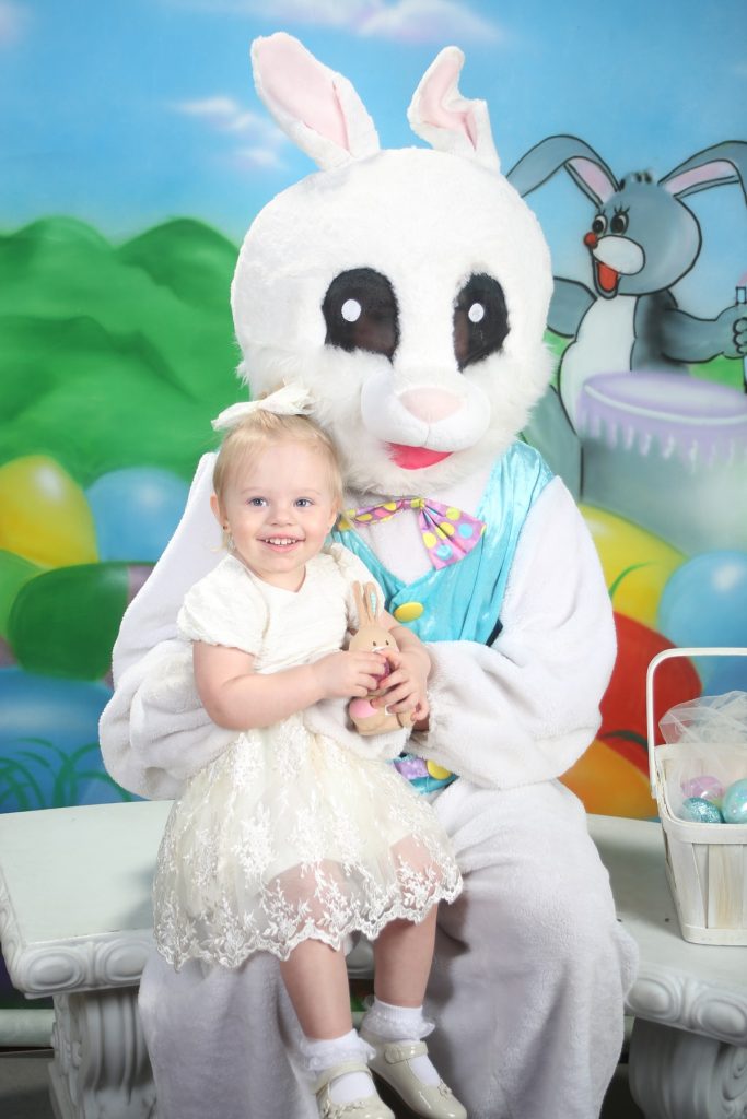 person in a white bunny suit with a girl on their lap