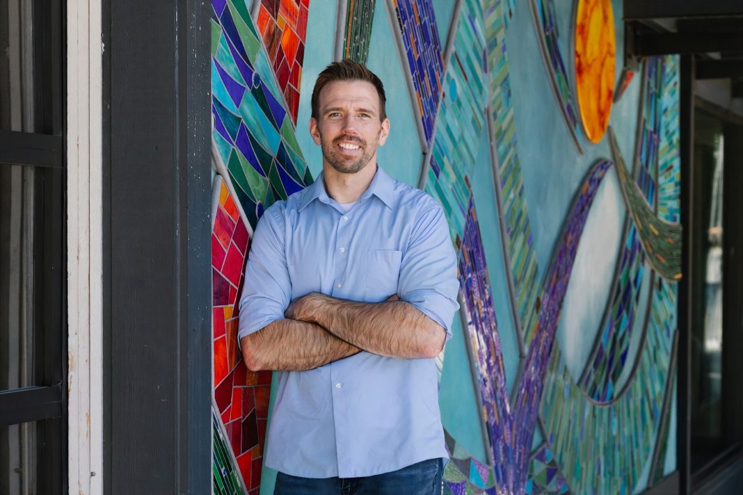 James Vanderholm standing in front of a stained glass window