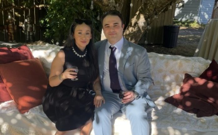 Penrose-Physical-Therapy-Patient-Jessica-Oliver-1 Jessica Oliver (left) and husband Joshua Oliver (right) sitting on a bench seat at a low table with drinks