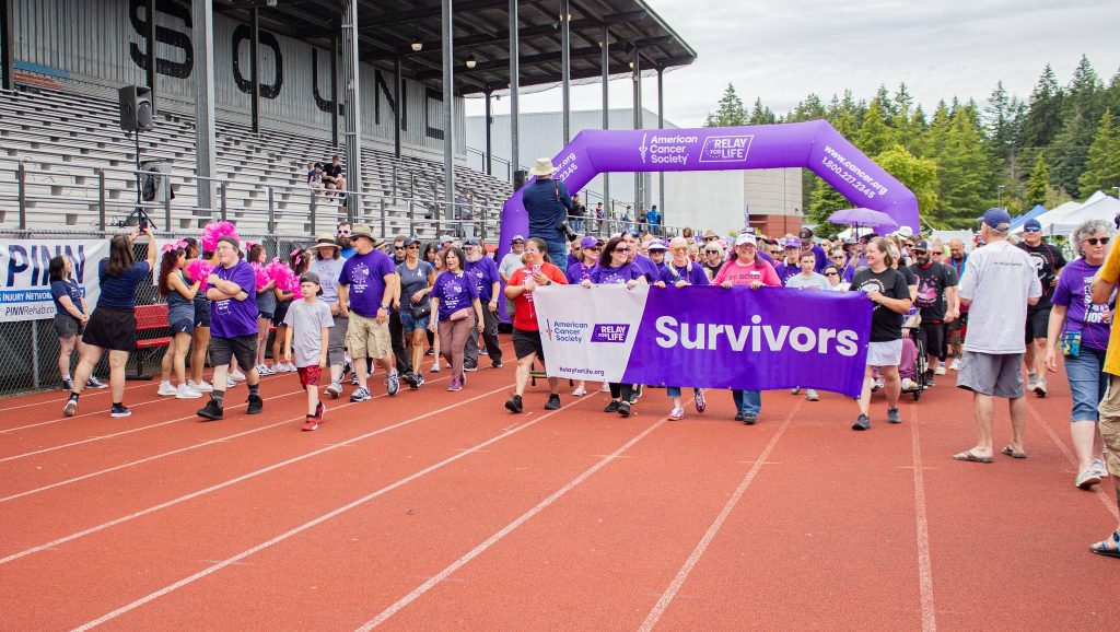 people walking a track in purple shirts for Relay for Life