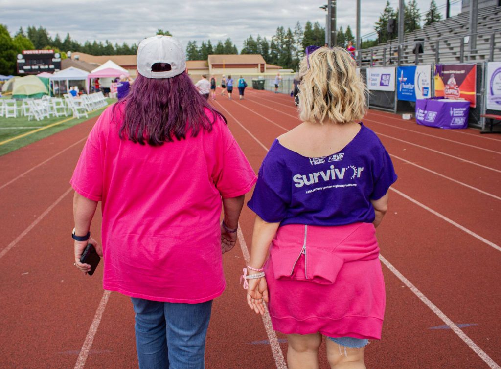people walking a track in purple and pink shirts for Relay for Life