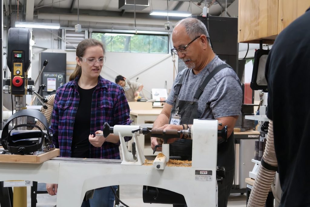 an teacher shows a student something on a machine at Lacey MakerSpace