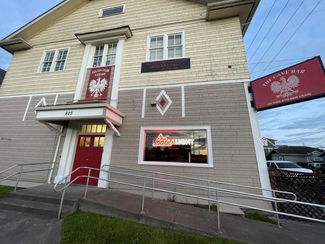 The Cave Bar and Polish Club building with a red The Cave Bar sign