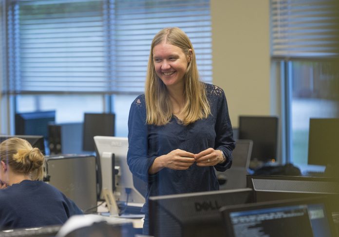 Saint-Martins-University-Andrea-Kunder-science-gran Saint Martin's University's Andrea Kunder standing in a computer lab smiling