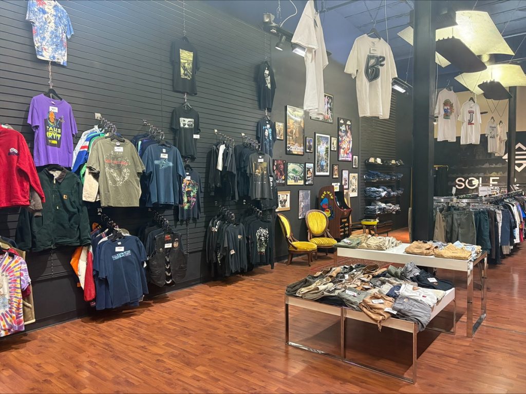 A Capital Mall store with vintage clothing on the walls, on low tables and racks and even hanging from the ceiling