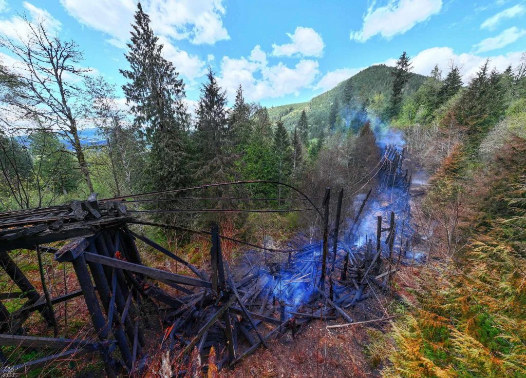the remains of the trestle bridge, blackened and fallen from the April 30th fire