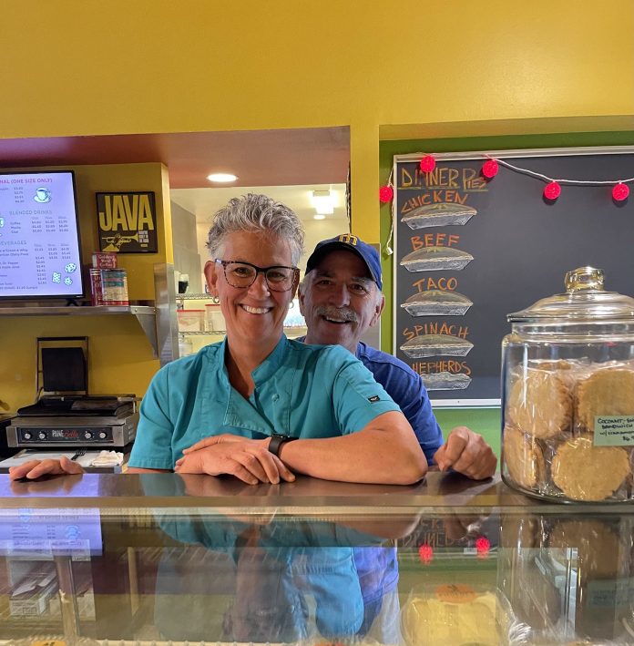 Phoebes-Pastry-Cafe-closure-Olympia-bakery Phoebe standing behind the counter at Phoebe's Pastry Cafe with Dan standing behind her, smiling over her shoulder