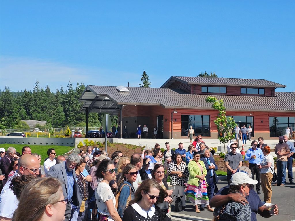 a large crowd stands in the parking lot of the Tenino Agricultural Innovation Park for the grand opening