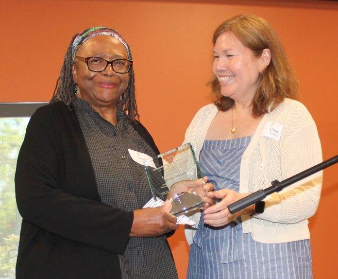 olympia lonnie locke peacemaker award 2025 - 8914 Dispute Resolution Center board member Eileen Yoshina (right) handing a glass trophy Peacemaker Award to Lonnie Locke (left)