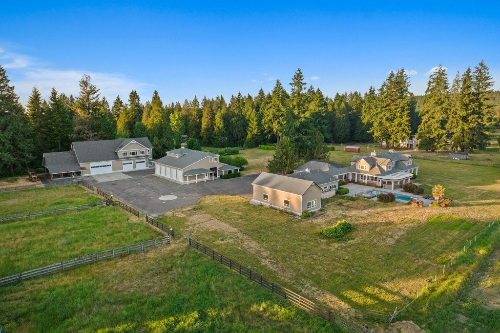 An Aerial photo of the side of 7417 Johnson Road SE with views of the oversized garage, shop, fields and more