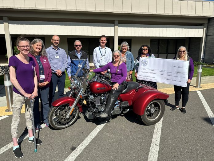 Mason Health New High Field Open MRI Construction Updates Foundation Events Check Presentation Bikers for Babies 2024 a group of people stand next to a red motorcycle, two of them are holding a giant check.