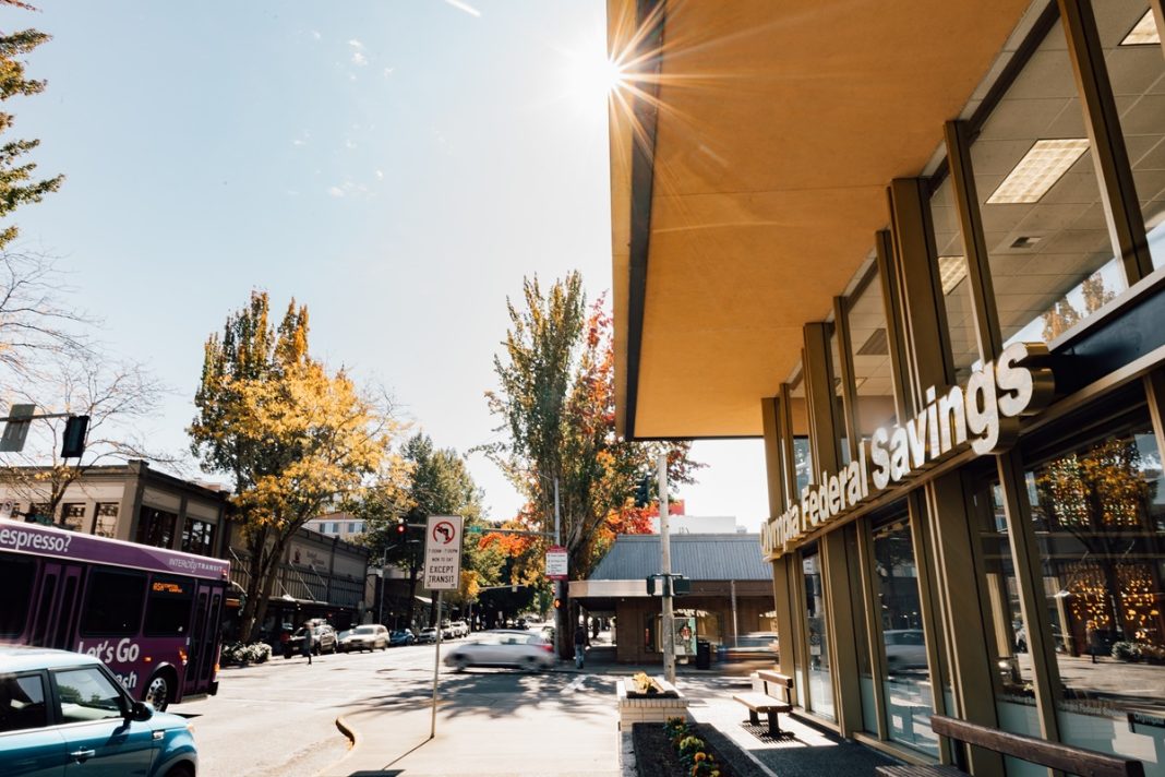 A photo of the side of the OlyFed building in Downtown Olympia with the sun behind it