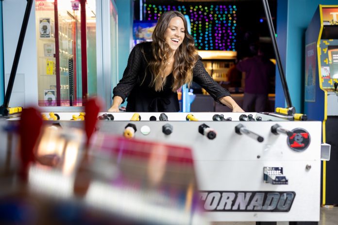 Olympia federal savings olyfed local banking Legends Arcade a woman laughs while playing with a foosball table at Legends Arcade