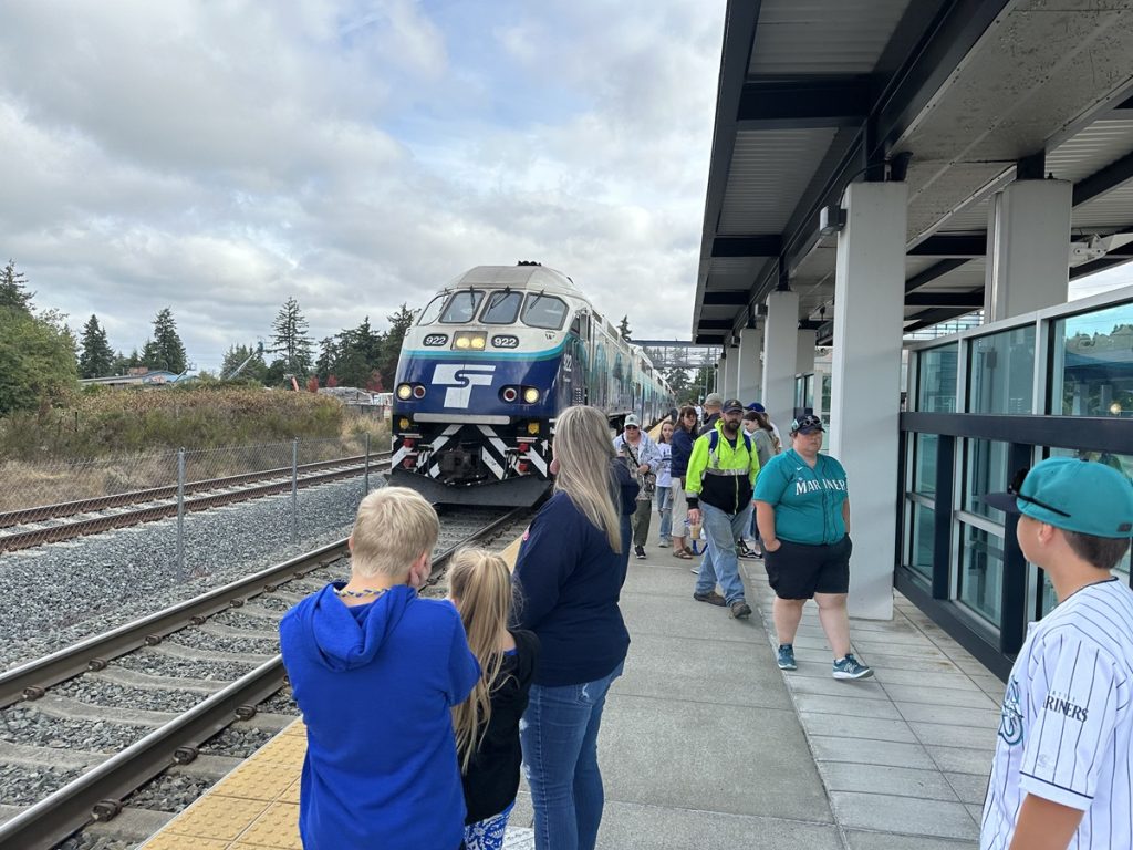 people on a train platform waiting for it to come 