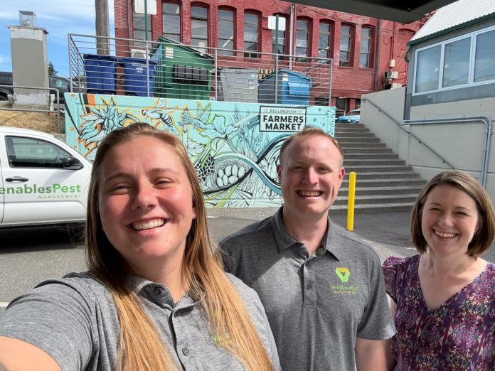 pest control bellingham venables pest (2) Marranda, Alex and Juliana pose for a selfie in front of a Venables truck and wall art with a blue design and the words Bellingham Farmers Market on it